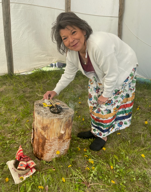 Brenda Genaille, Executive Director, Métis Nation of Alberta District 21 performing the smudging ceremony inside the tipi