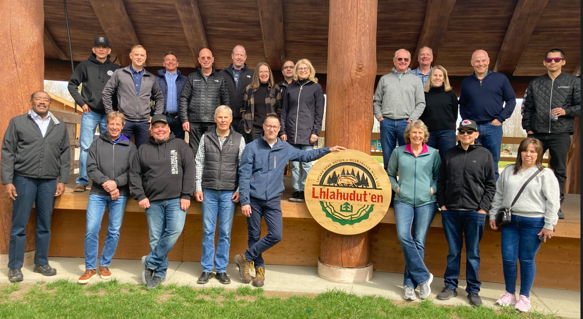 Members of West Fraser's executive and board pose for a picure outside in front of the wooden arbour.
