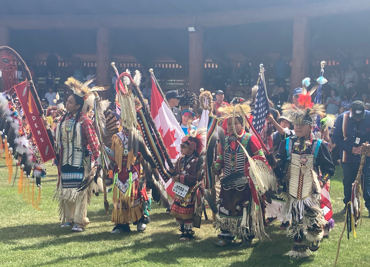 Dancers of all ages are dressed in colourful, intricate and culturally significant regalia featuring beadwork, feathers and leather. Carrying flags and sacred staffs, participants of all ages gather in the arbour during one of the pow wow’s Grand Entry moments.