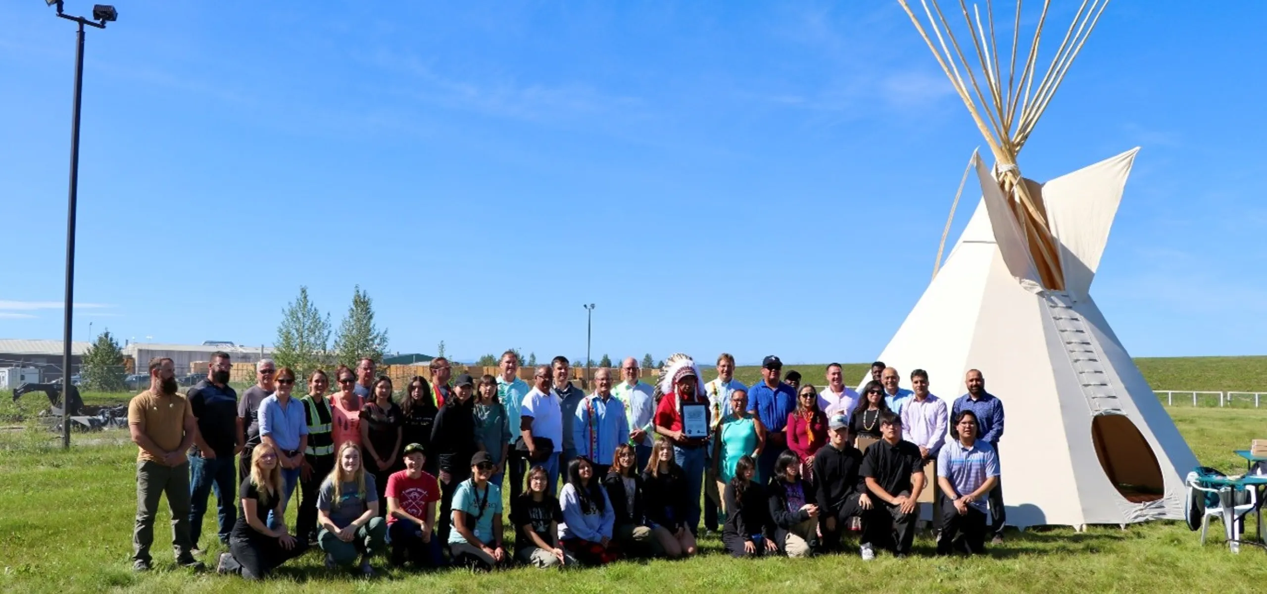 Members of the Montana First Nation and of the Sundre Forest Products team stand together by the tipi purchased from the Montana First Nation to celebrate the signing of the Good Relations Agreement.