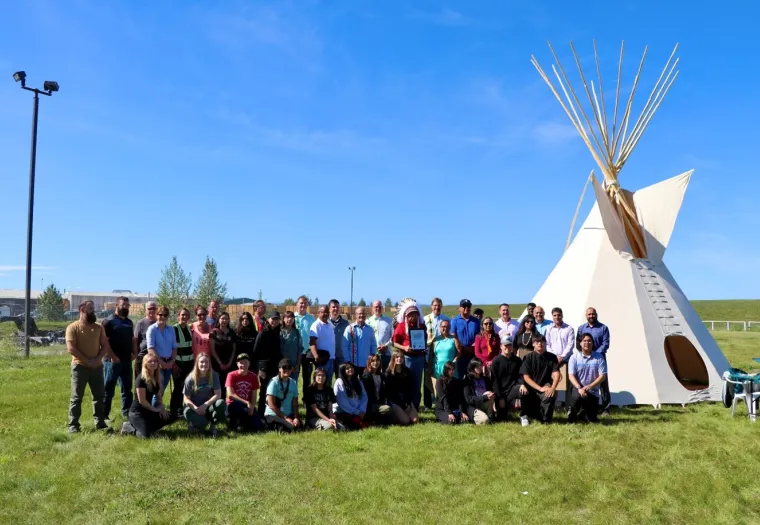 Members of the Montana First Nation and of the Sundre Forest Products team stand together by the tipi purchased from the  Montana First Nation to celebrate the signing of the Good Relations Agreement.