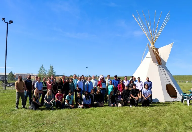 Members of the Montana First Nation and of the Sundre Forest Products team stand together by the tipi purchased from the  Montana First Nation to celebrate the signing of the Good Relations Agreement.