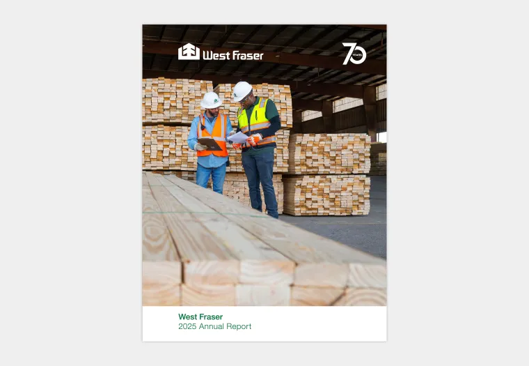 Two workers in safety gear stand in a lumber warehouse, reviewing a document. Stacks of wooden planks are in the background. Cover text reads "West Fraser 2025 Annual Report.
