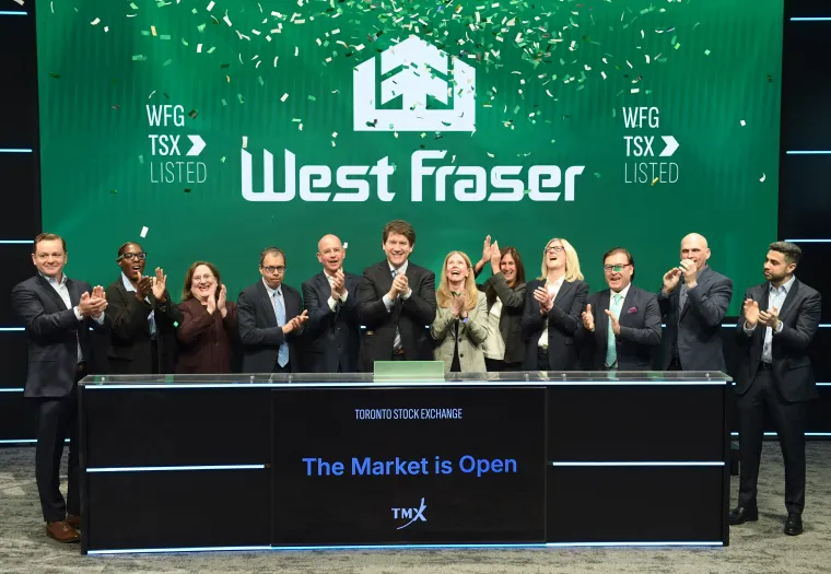 A group of West Fraser team member celebrate at the bell ringing as confetti falls on stage at the Toronto Stock Exchange, with a sign reading “West Fraser” and “The Market is Open.”