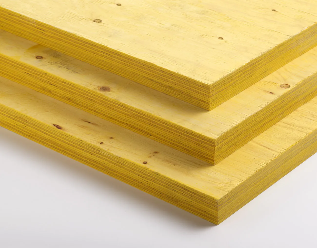 Three stacked sheets of yellow plywood, viewed from the side.
