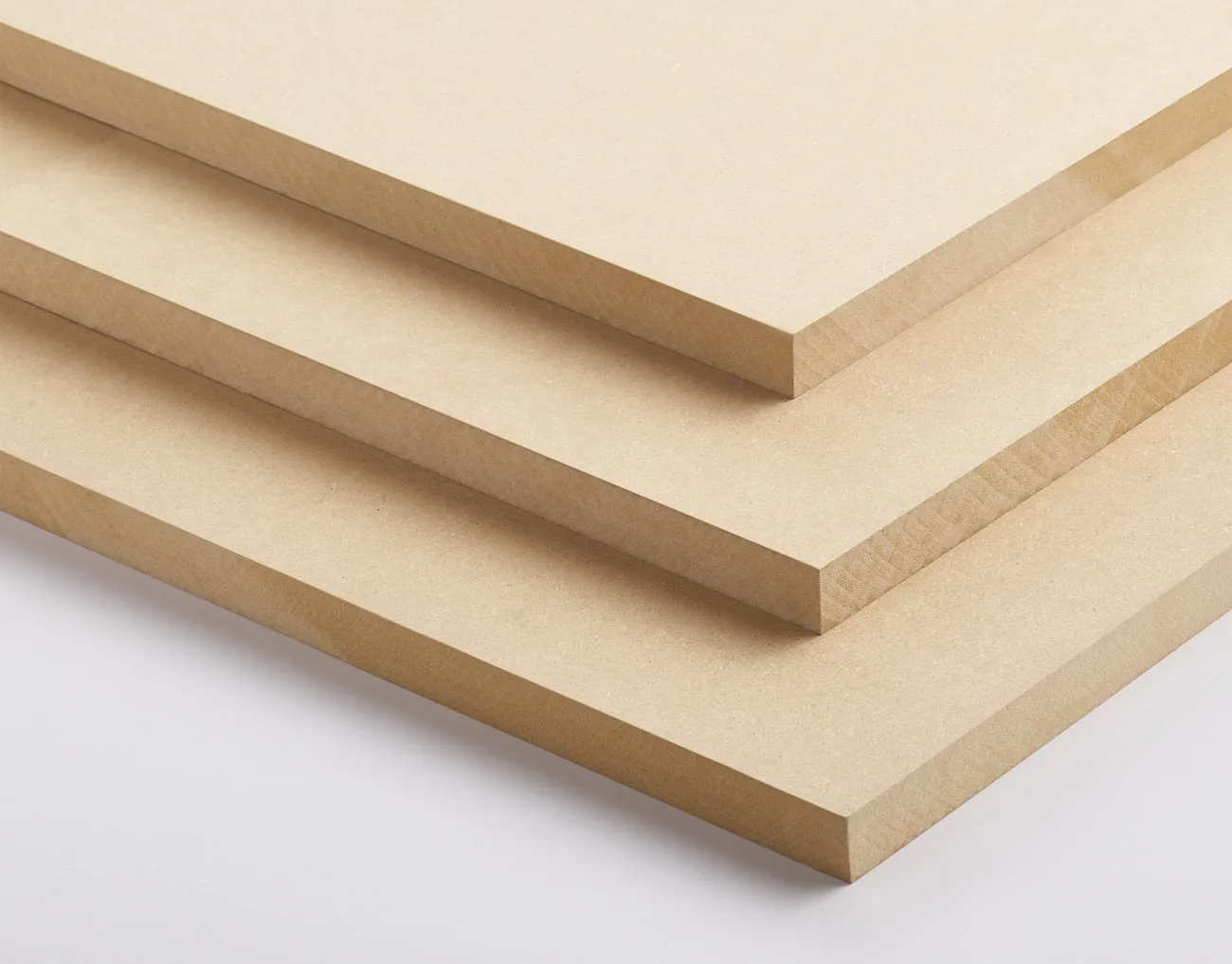 Three stacked sheets of medium-density fiberboard (MDF) on a flat surface.