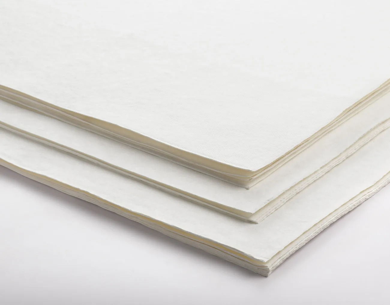 A stack of white paper sheets on a plain surface.