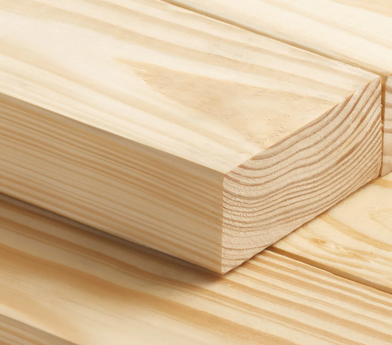 Close-up of stacked wooden planks with visible grain patterns on a light background.