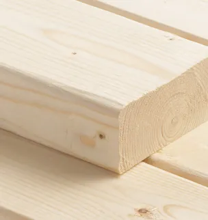 Close-up of stacked light-colored wooden planks with visible grain patterns.