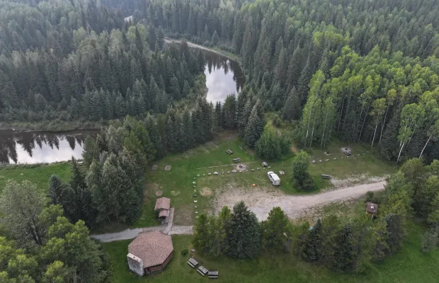 A view of the Weald Group Campground, with the shelter visible in the lower forefront of the picture and the Embarras River behind it.
