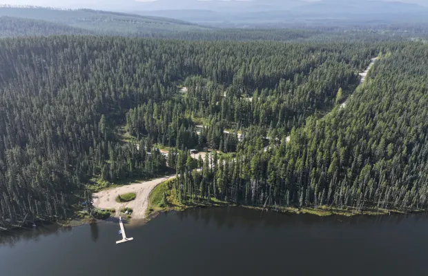 The boat launch, dock, and day-use area are clearly visible in the forefront of the picture. The 27-site campground is immediately behind the day-use area.