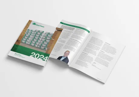 Open financial report 2024 with the cover showing the an outside walkway at mill with product, and the company logo. Inside pages contain the CEO message text, a portrait the CEO, and his signature.