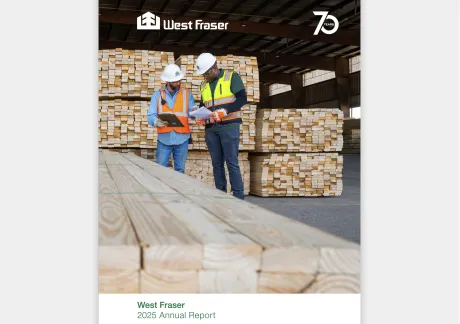 Two workers in safety gear examine documents in front of large stacks of lumber at a West Fraser facility, featured on the cover of the 2025 Annual Report.