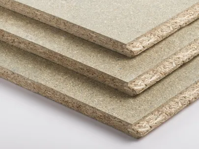 Close-up of three stacked particle boards with visible wood chips and layered texture on the edges.