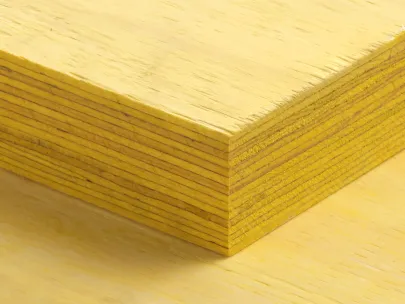 Close-up of a stack of yellow plywood sheets with visible layers and a smooth surface.
