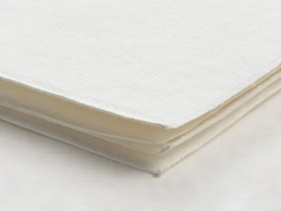 A stack of white paper napkins on a white surface.