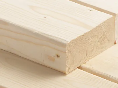 Close-up of stacked light-colored wooden planks with visible grain patterns.